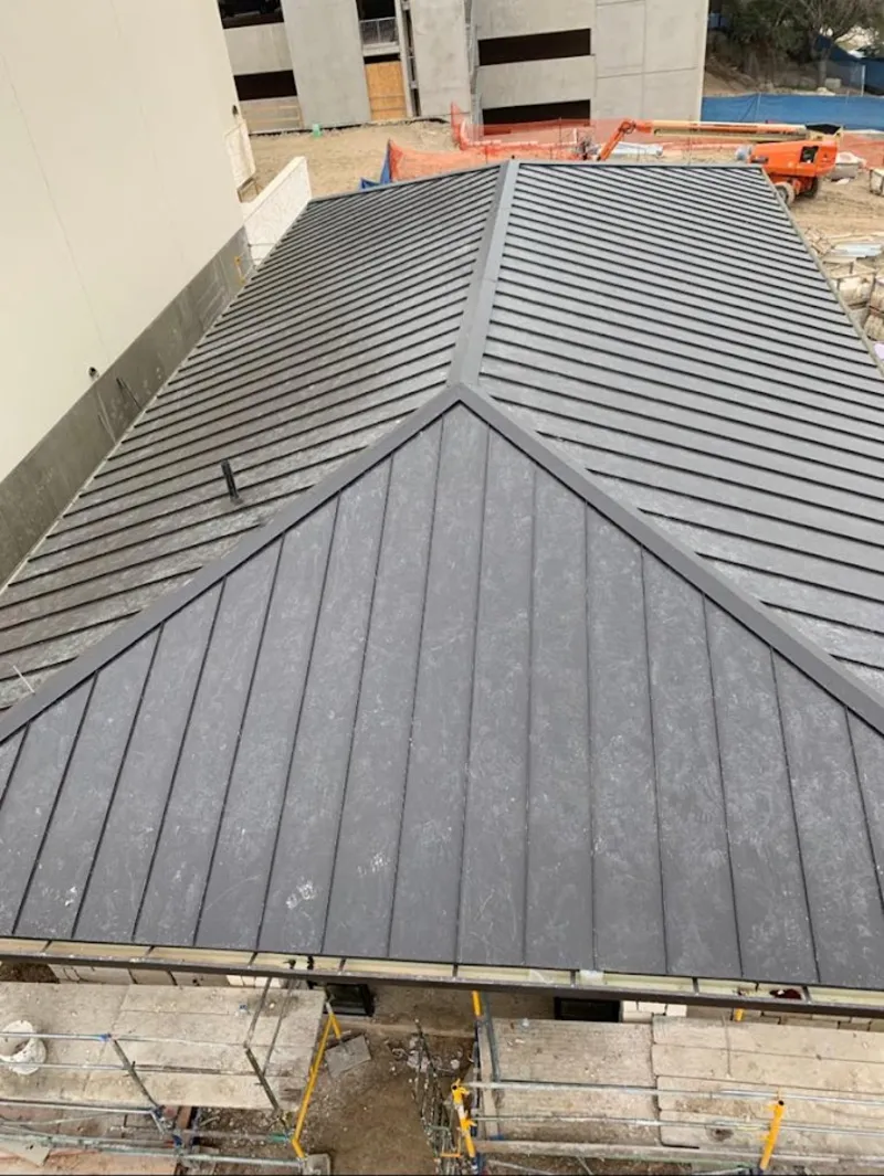 Commercial metal roof construction with crane equipment in Booneville