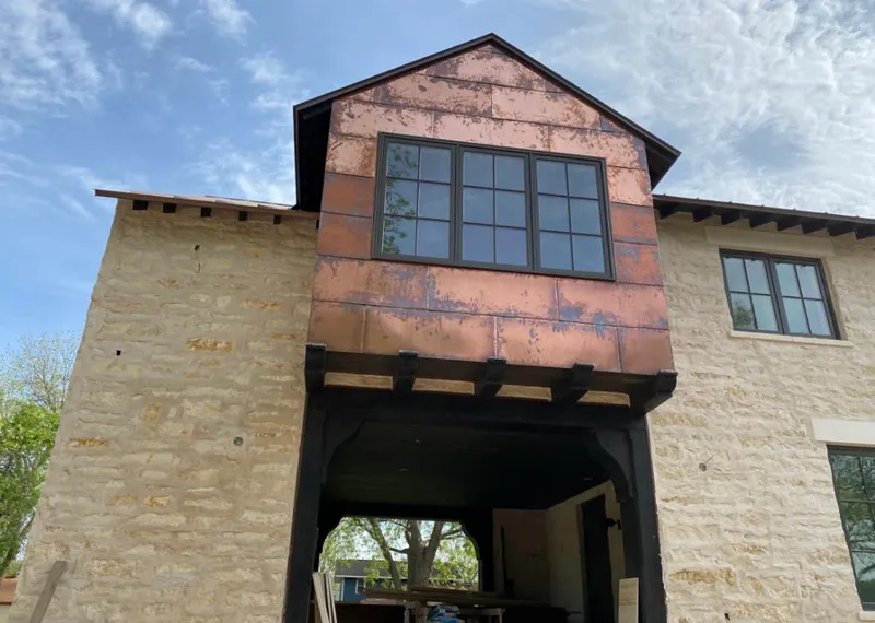 Copper metal panel facade on a stone building for Skylight Installation in Booneville